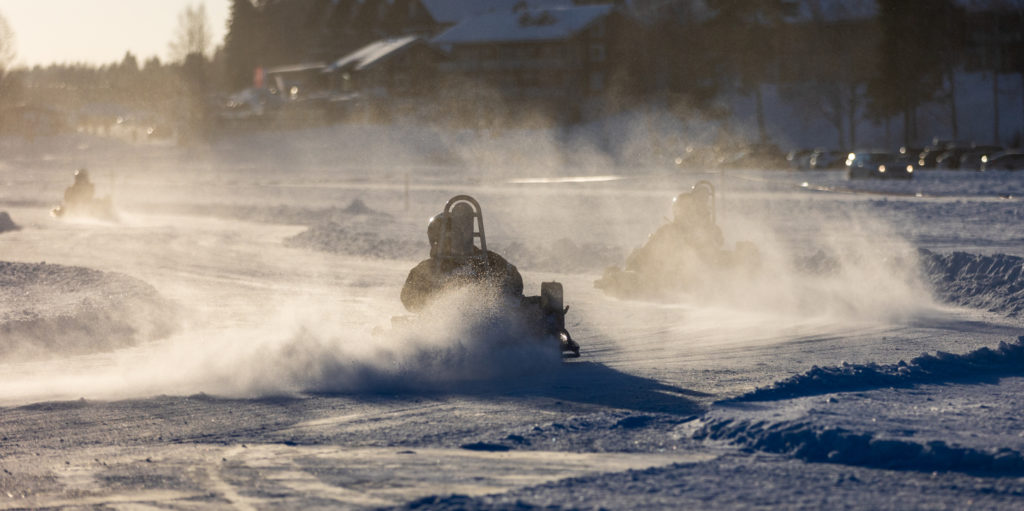 Ice karting action on sunny winter day. Motorsports racing activity in Finland.